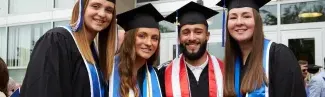 Four University of New England students pose in their graduation cap and gowns